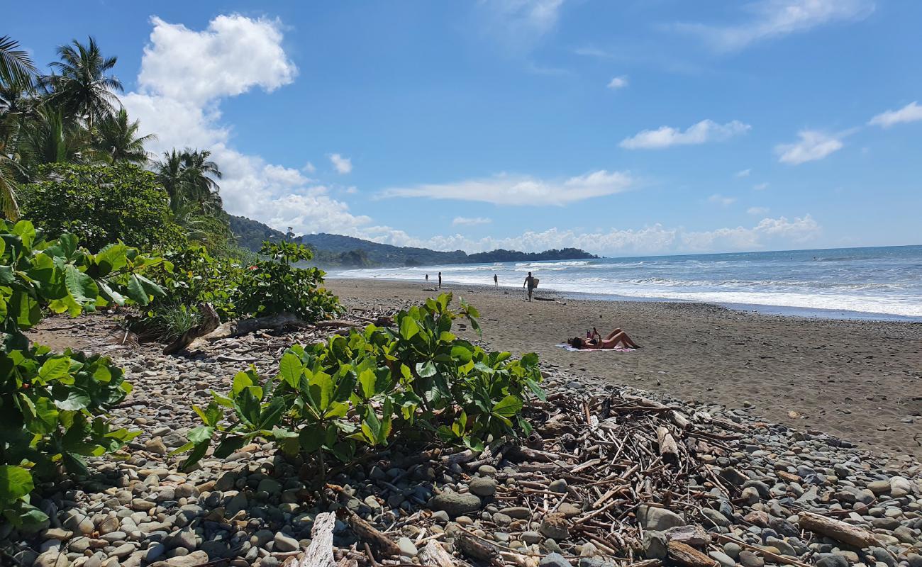 Photo of Playa Dominical with gray sand &  rocks surface