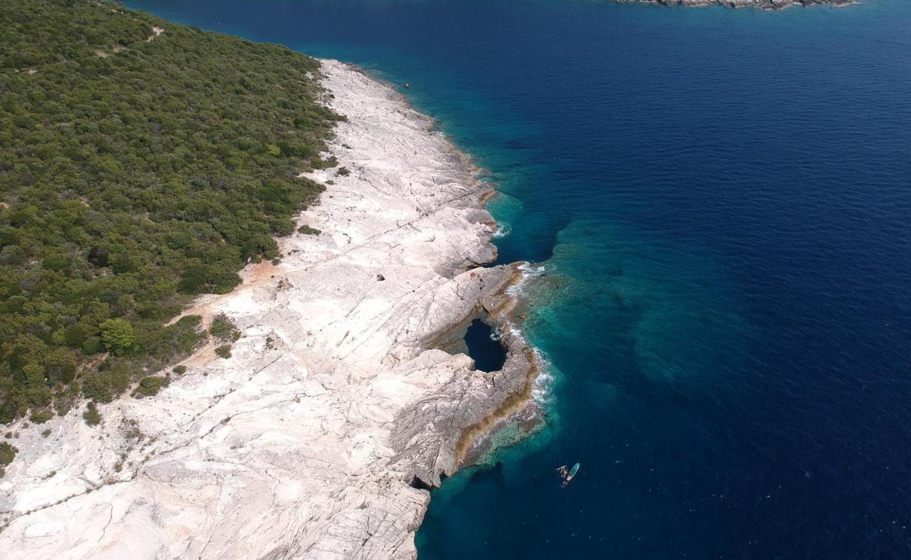 Photo of Dragon's Eye Sea Cave with rocks cover surface