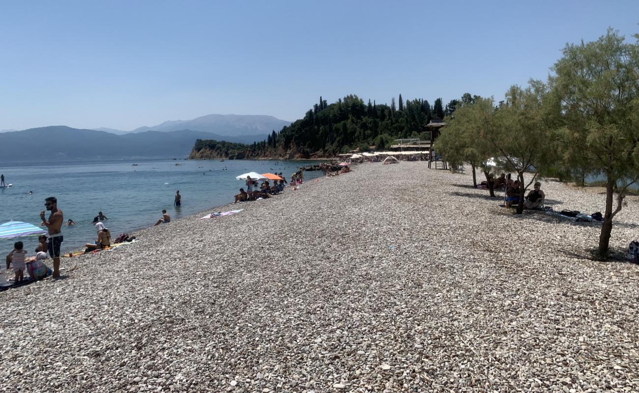 Photo of Blue lake beach with gray fine pebble surface