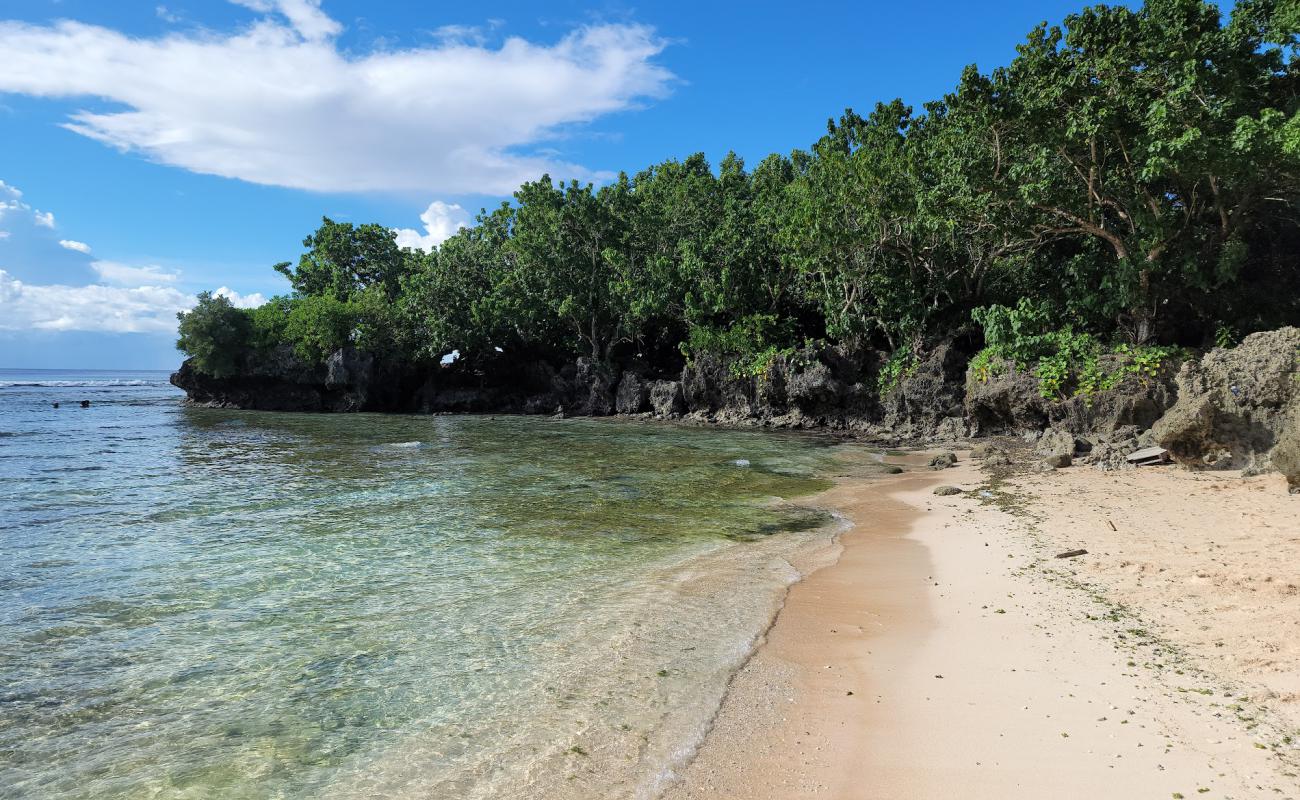 Photo of Tanguisson Beach with bright sand & rocks surface