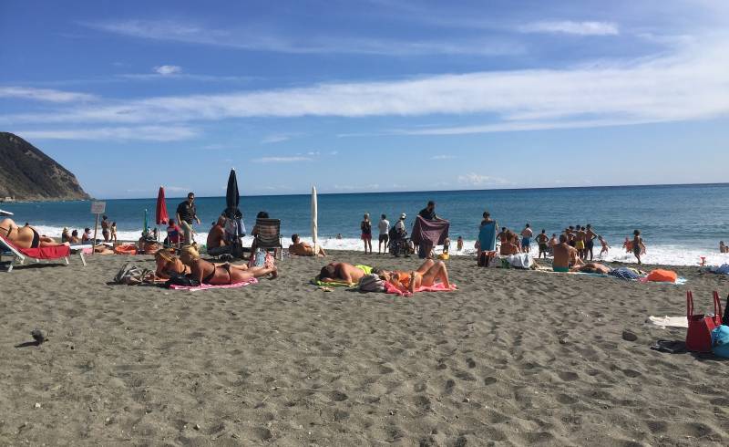 Photo of Riva Ponente with black sand & pebble surface