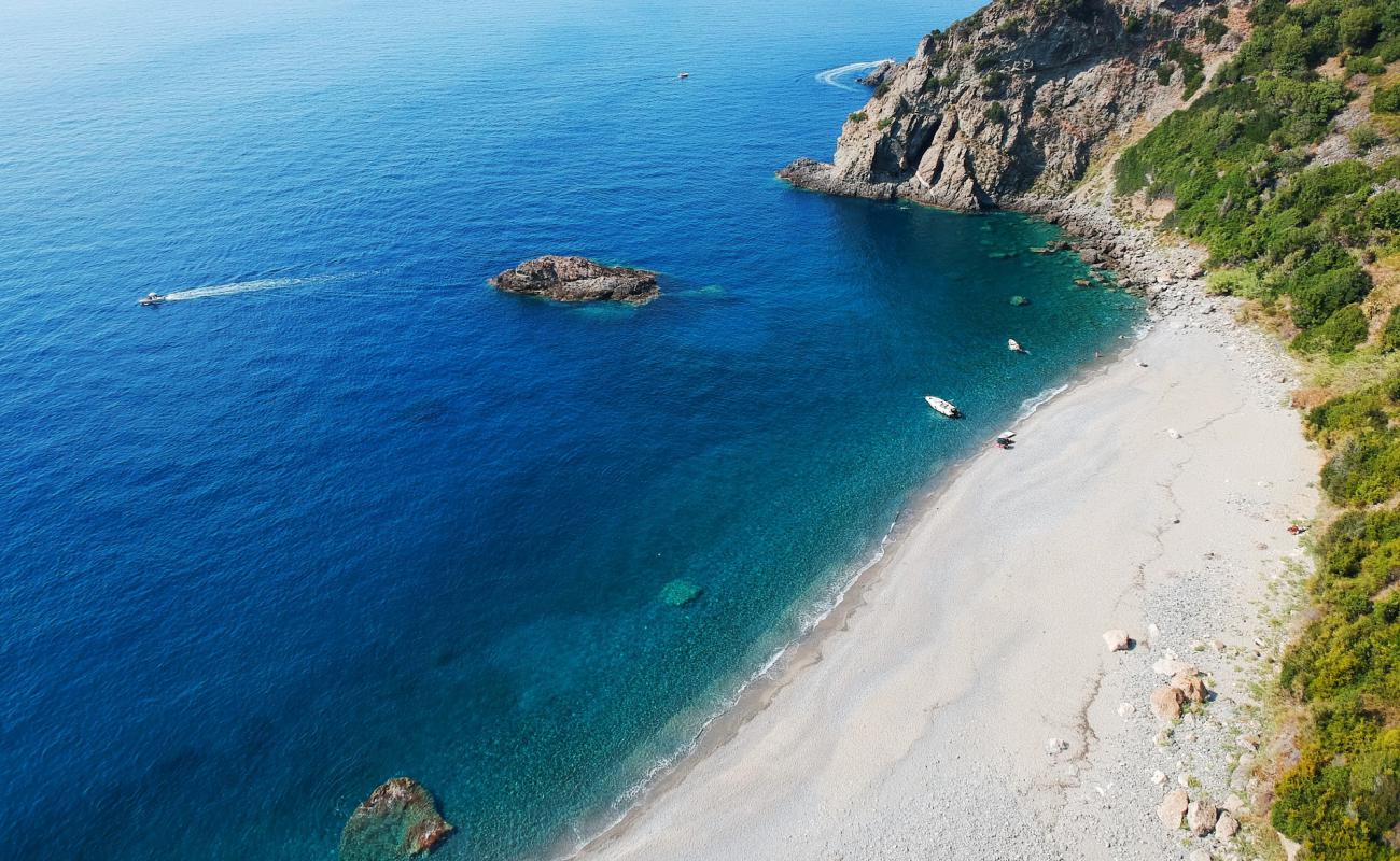 Photo of Cala Janculla with gray sand &  pebble surface