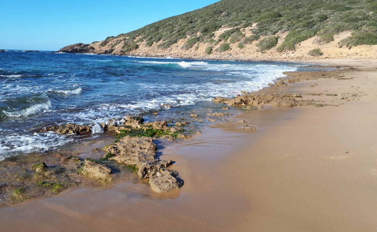 Photo of Portu Sessini with bright sand & rocks surface