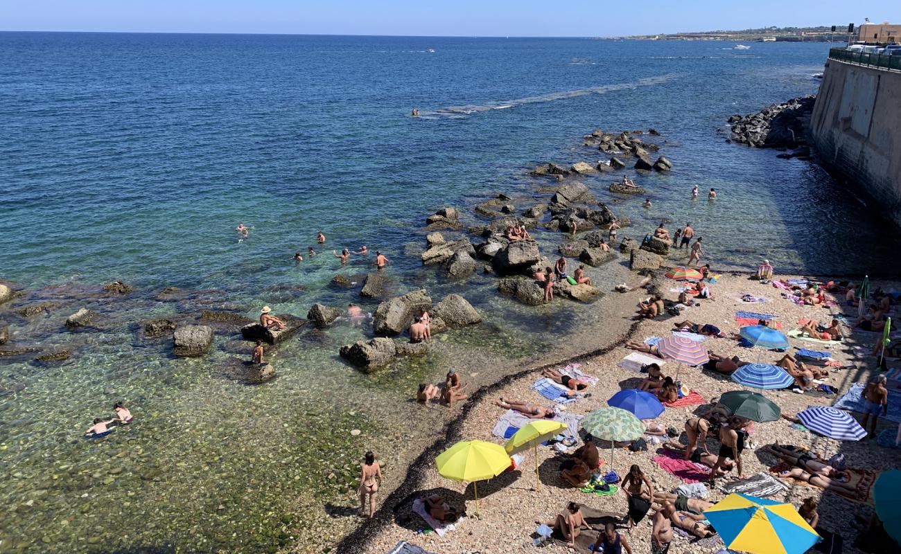 Photo of Cala Rossa Beach with gray sand &  rocks surface