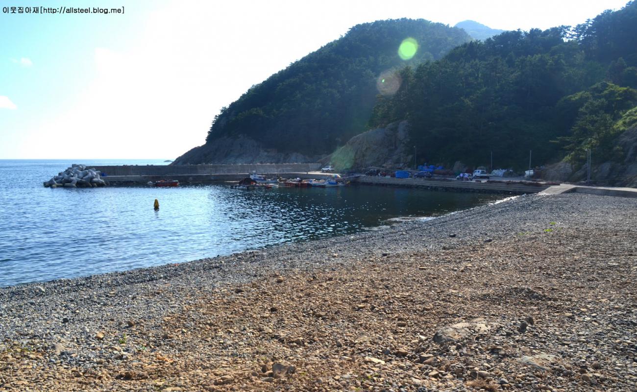 Photo of Deokdong Beach with gray pebble surface