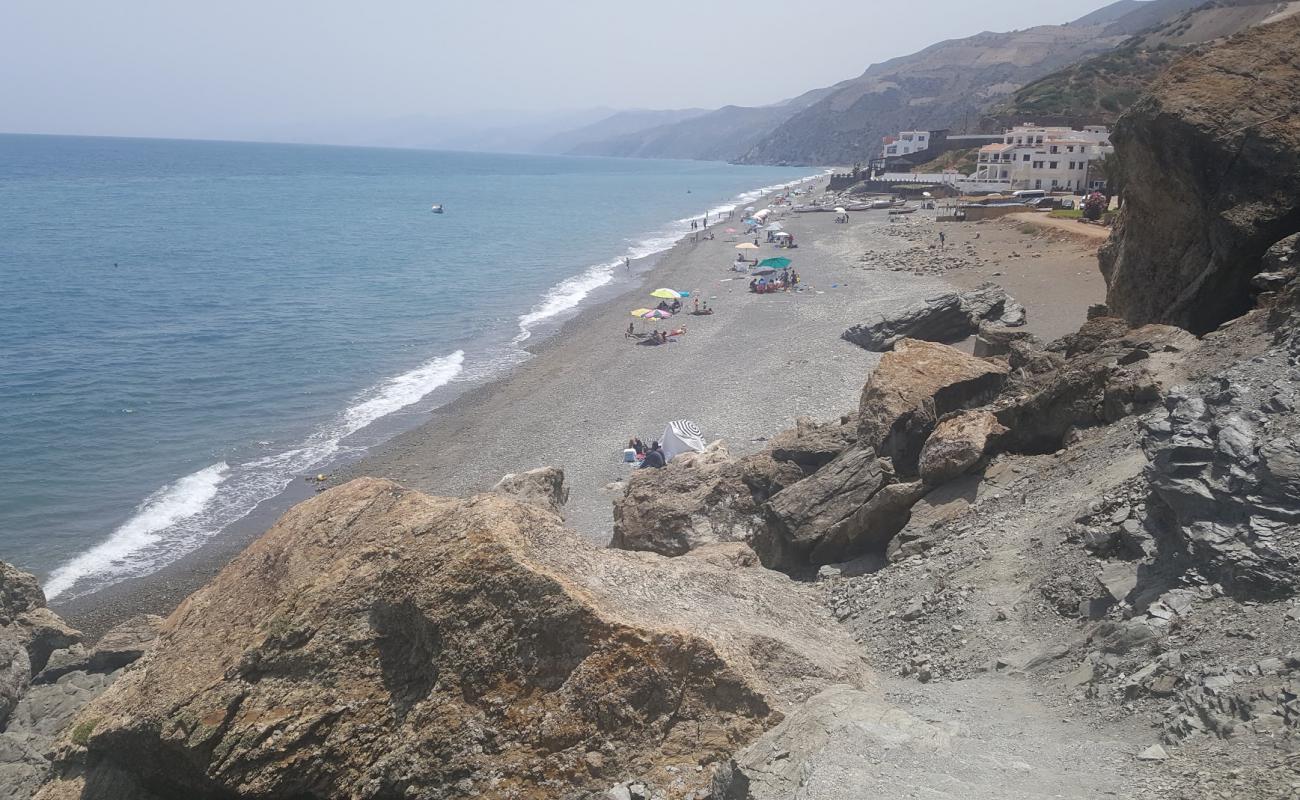 Photo of Plage Jnanich with gray pebble surface