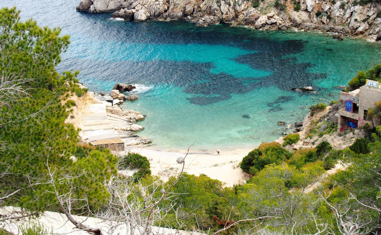 Photo of Cala D'en Serra with brown sand &  rocks surface