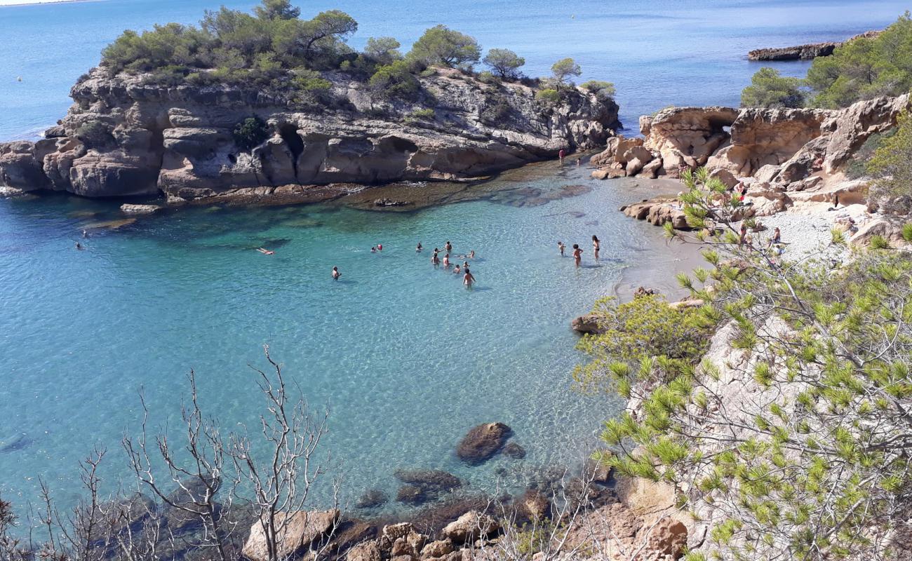 Photo of Cala de l'Aliga with brown sand &  rocks surface