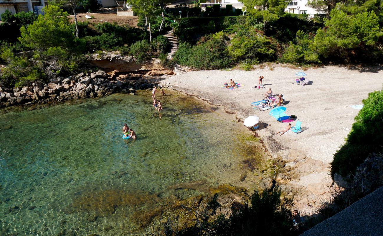 Photo of Cala Llobeta with brown sand &  rocks surface