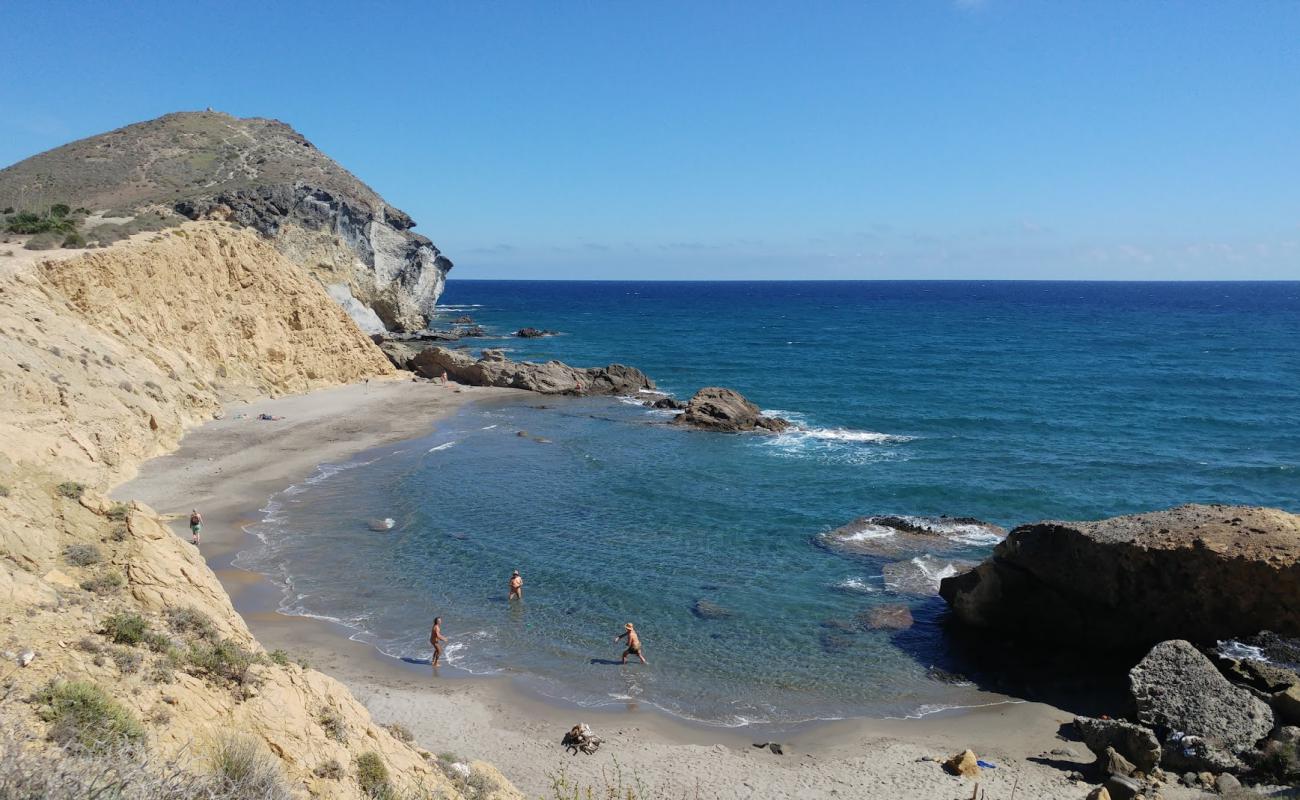 Photo of Cala de los Amarillos with gray sand surface