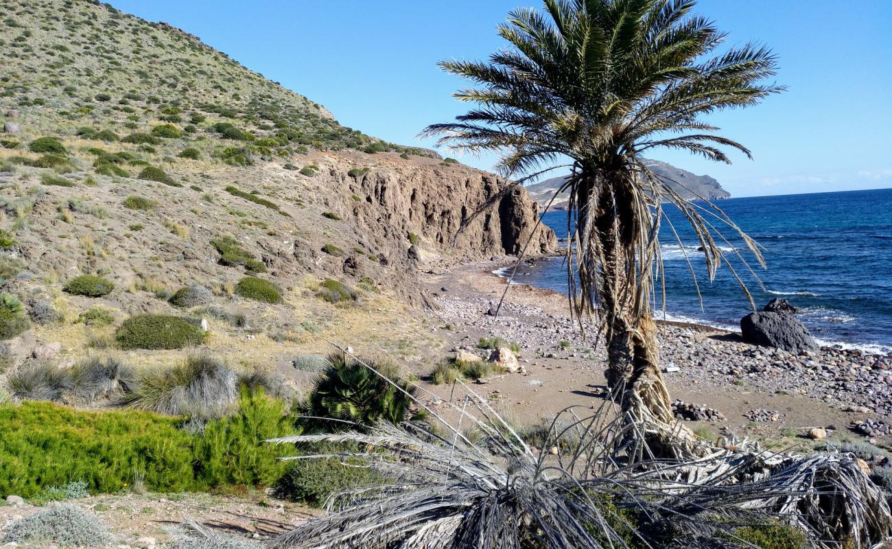 Photo of Cala de los Toros with gray sand &  rocks surface