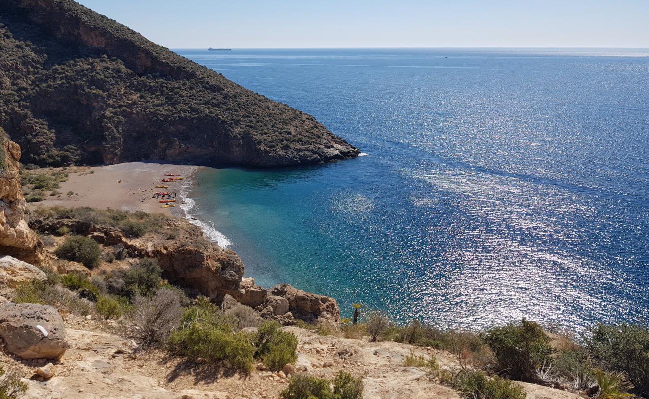 Photo of Cala Aguilar with gray shell sand surface