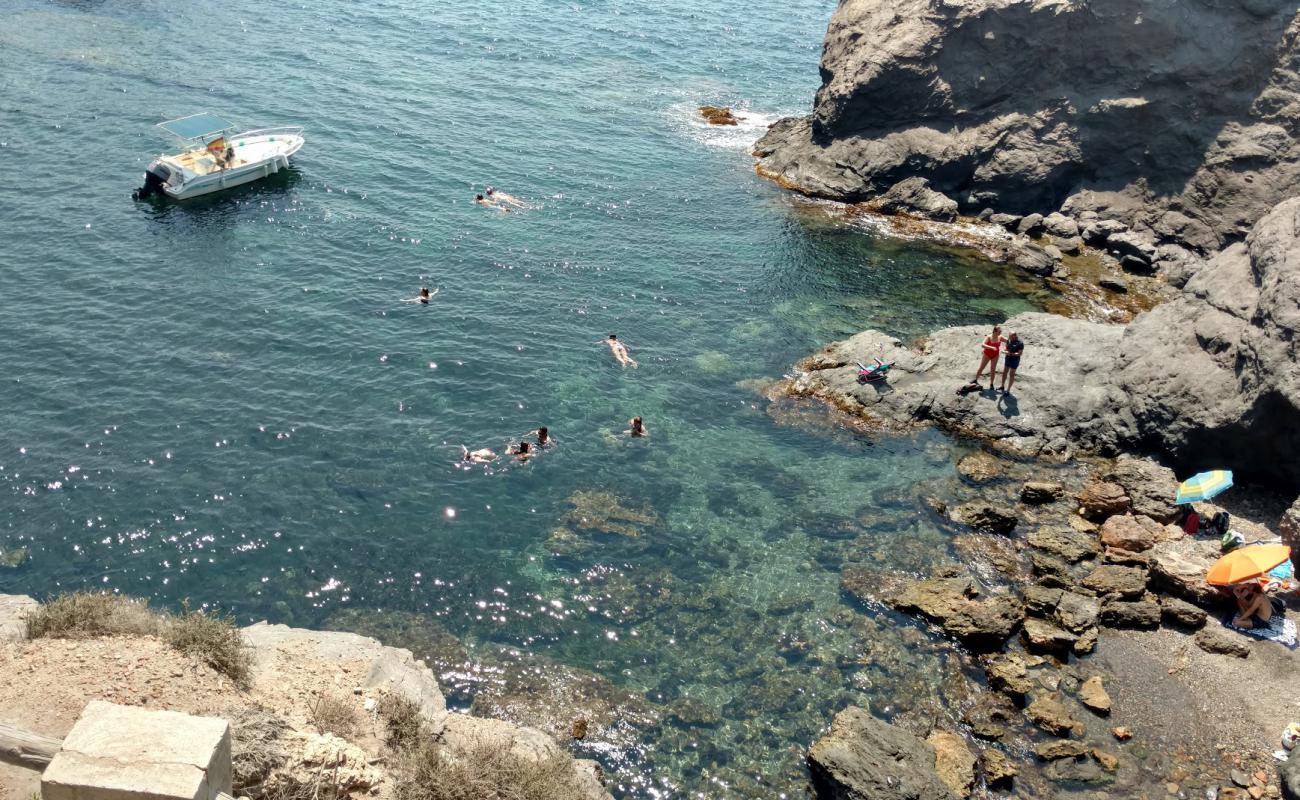 Photo of Cala de las Melvas with black sand & pebble surface