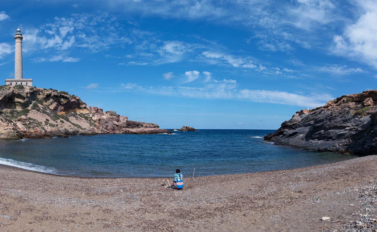 Photo of Playa de la Calafria with gray sand &  pebble surface