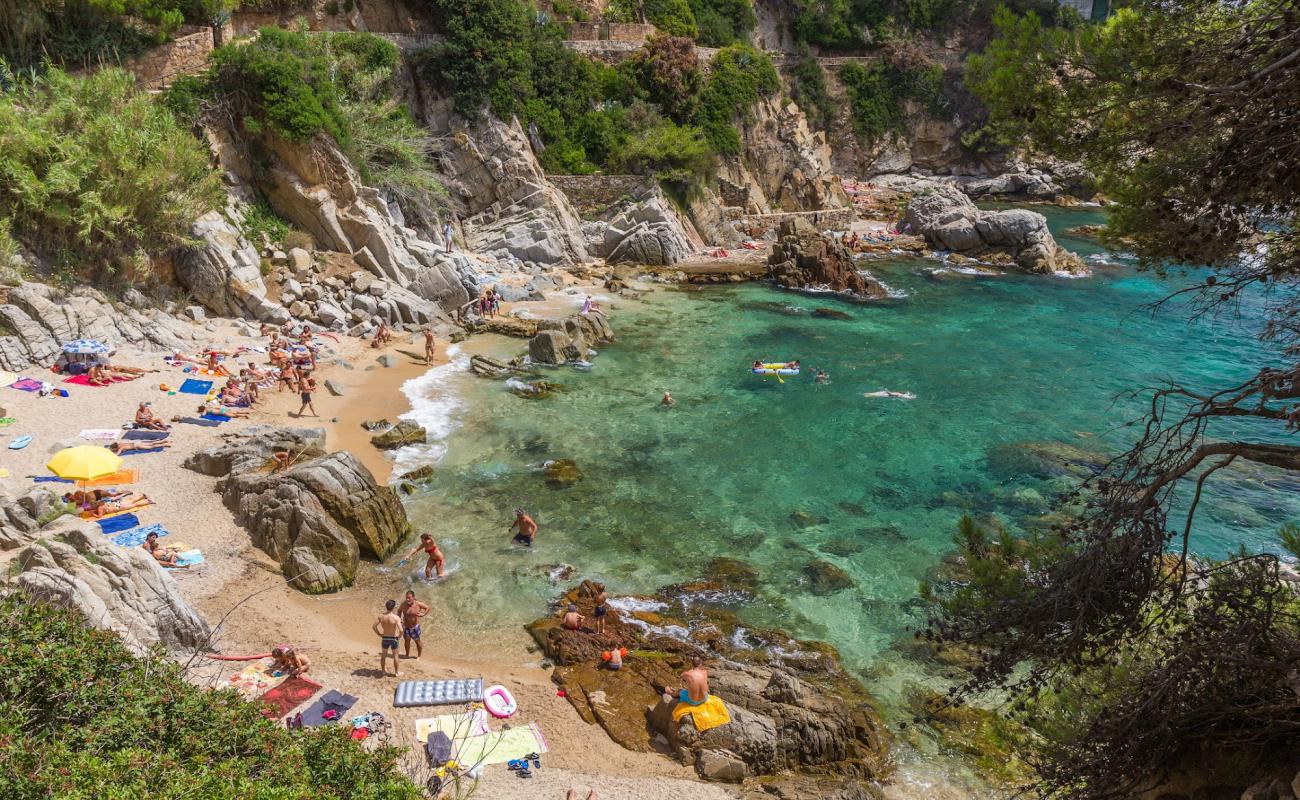 Photo of Cala d'en Trons with bright sand & rocks surface