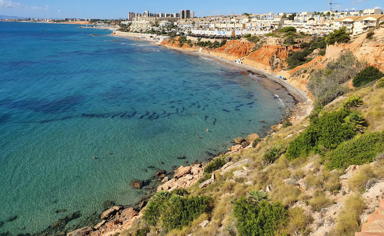 Photo of Cala Aguamarina with gray sand surface