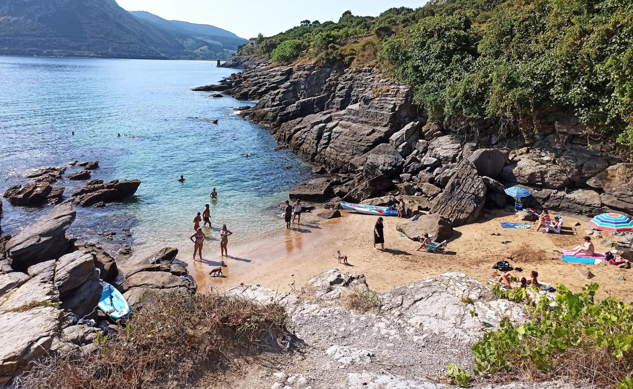 Photo of Cala Sonabia with gray sand &  rocks surface