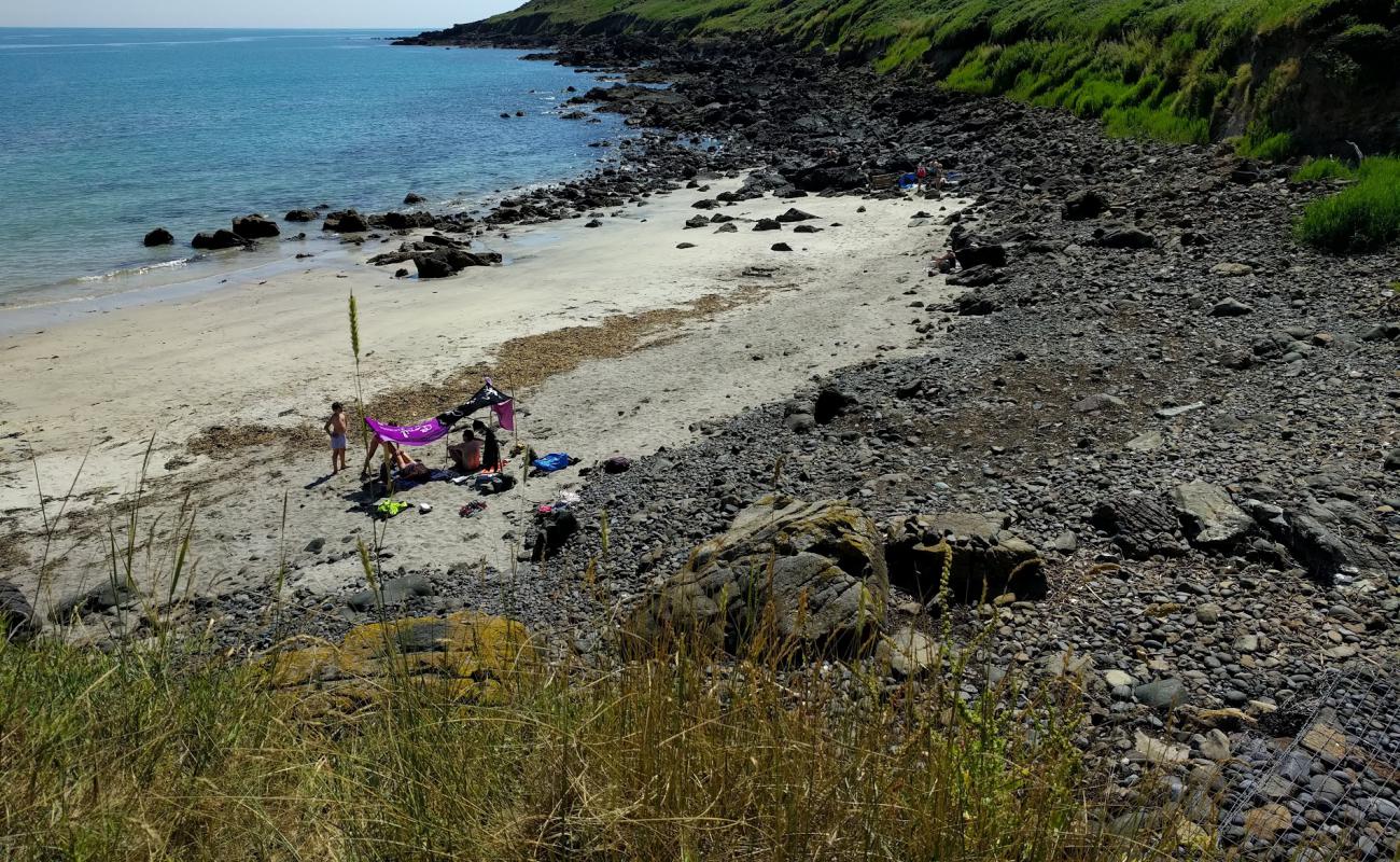 Photo of Porthbeer Cove with bright sand & rocks surface