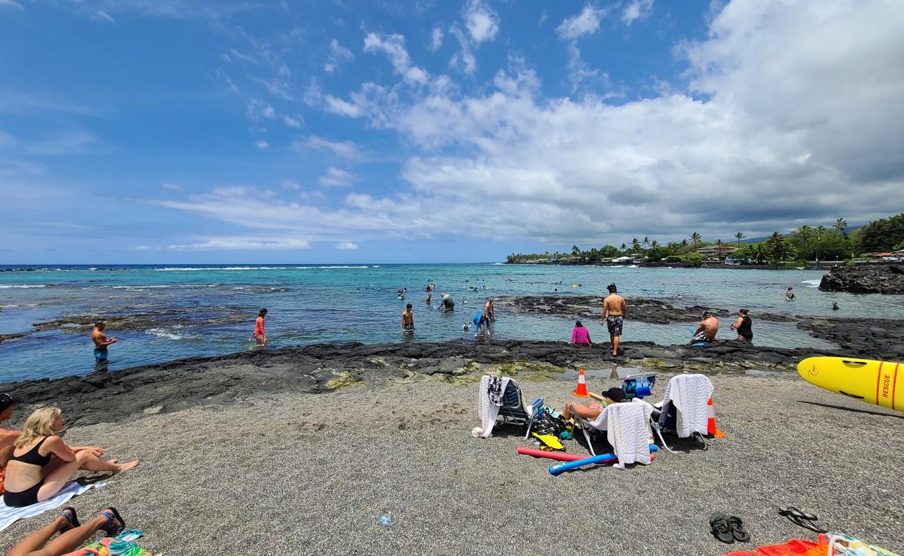 Photo of Kahalu’u Beach with gray sand &  rocks surface