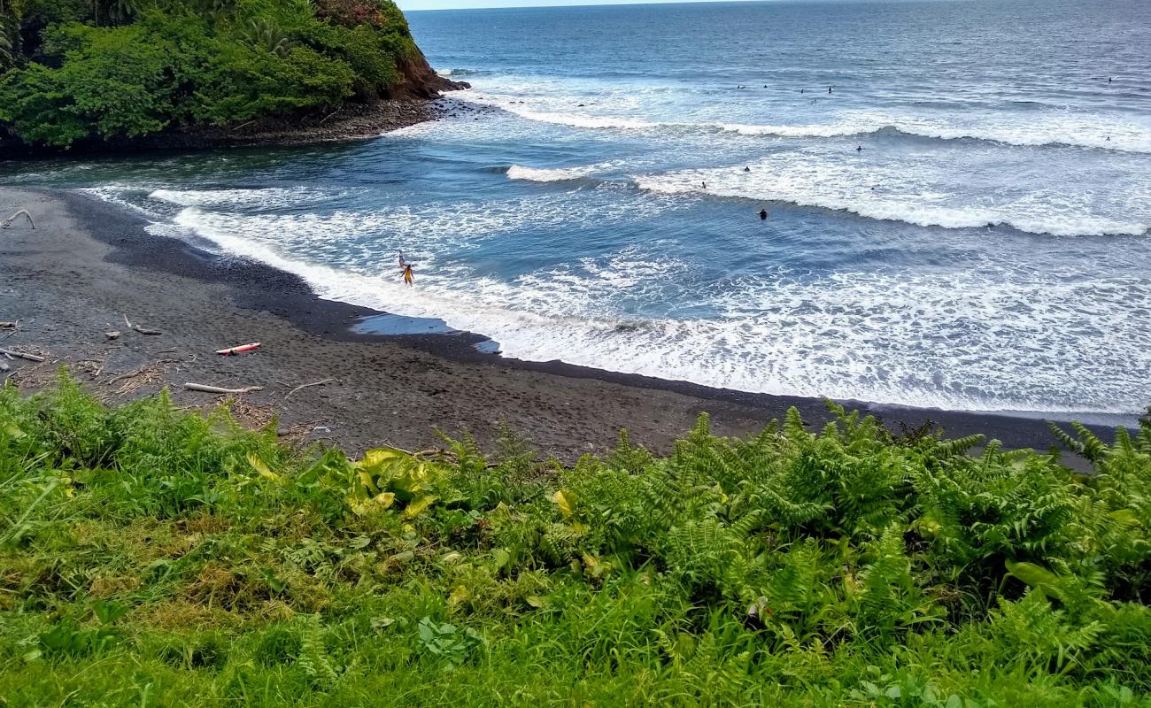 Photo of Honoli'i Beach with gray sand &  rocks surface